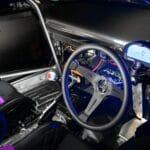 Wnętrze auta wyścigowego z kierownicą i cyfrowym kokpitem