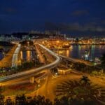 Nocne miasto nad zatoką z ruchliwą autostradą pełną świateł