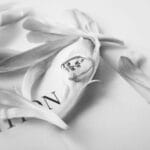 Jak dbać o srebrną biżuterię, aby długo zachowała blask i nie ciemniała Srebrny pierścionek wśród delikatnych płatków na jednolitym tle