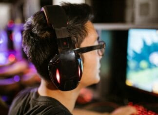 Jak ustawić opóźnienie i smoothing w head trackingu, żeby obraz nie pływał Młody gracz w słuchawkach skupiony na ekranie komputera