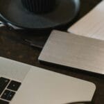 Zewnętrzny dysk podłączony kablem USB do laptopa na biurku