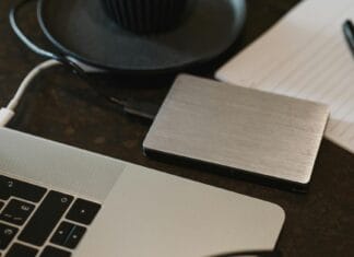 Zewnętrzny dysk podłączony kablem USB do laptopa na biurku