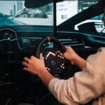 Gracz w realistycznym symulatorze jazdy z zaawansowaną kierownicą direct drive
