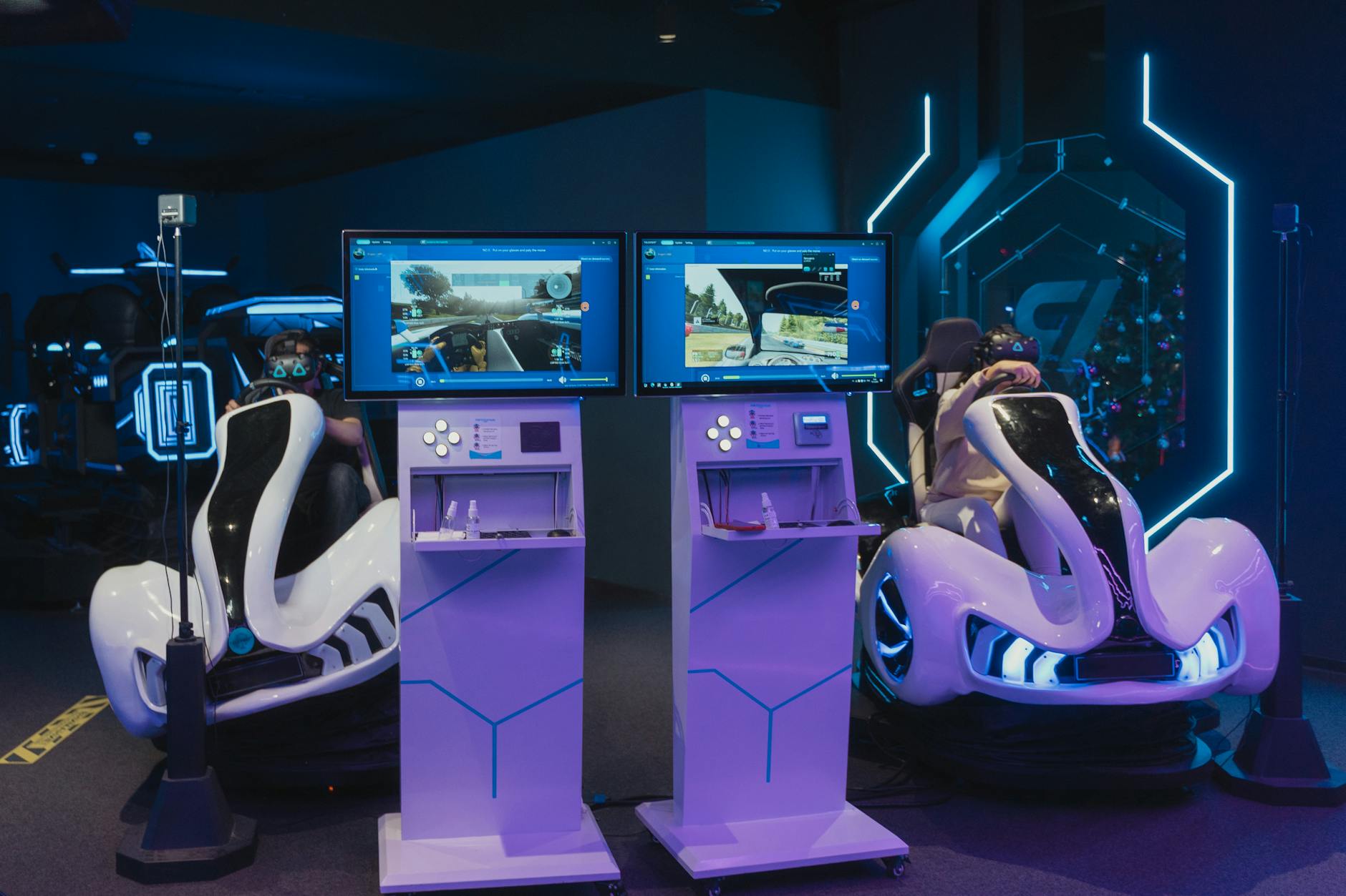 Gracze w futurystycznych fotelach gamingowych z VR w salonie arcade