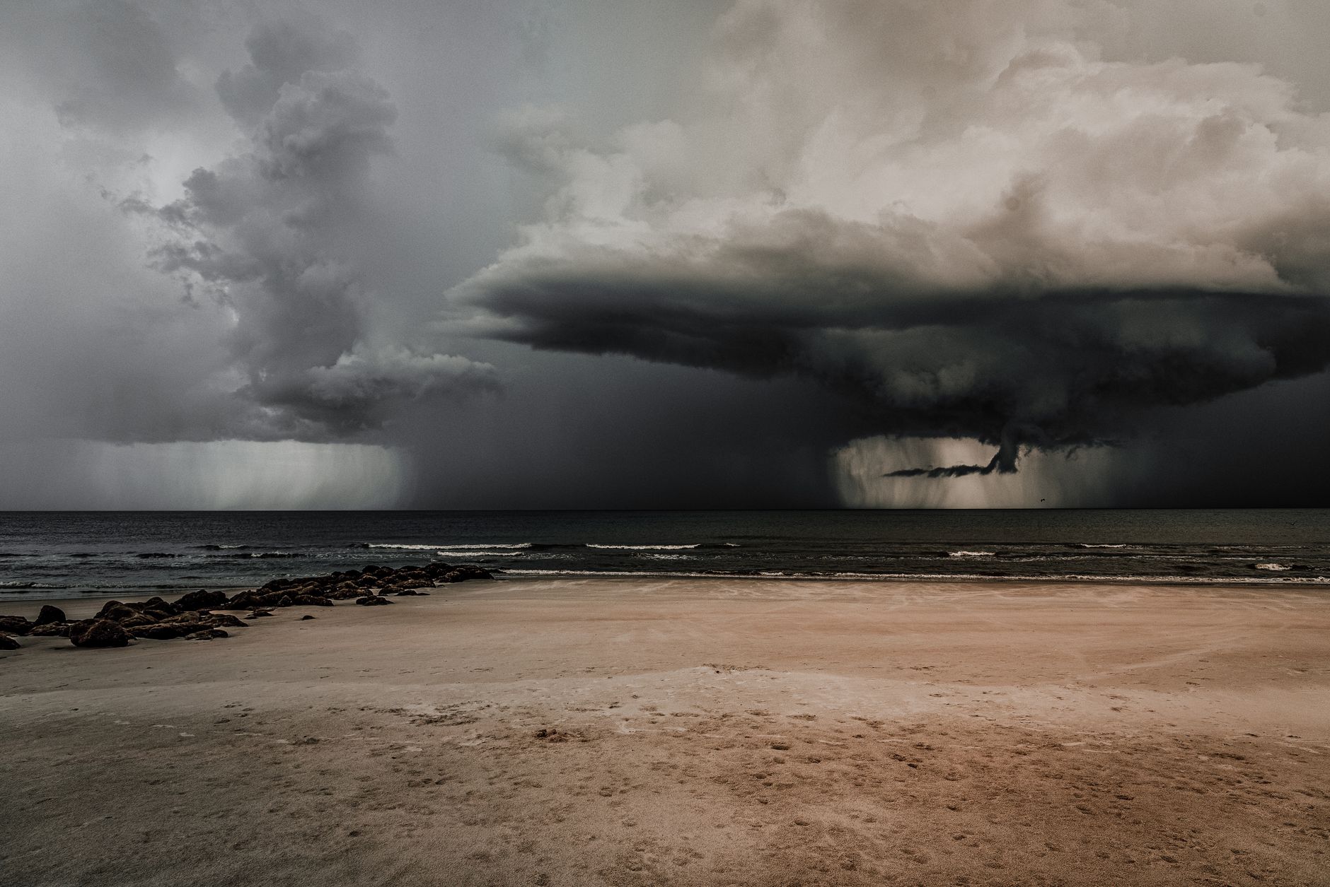 Ciemne chmury burzowe nad pustą, nadmorską plażą