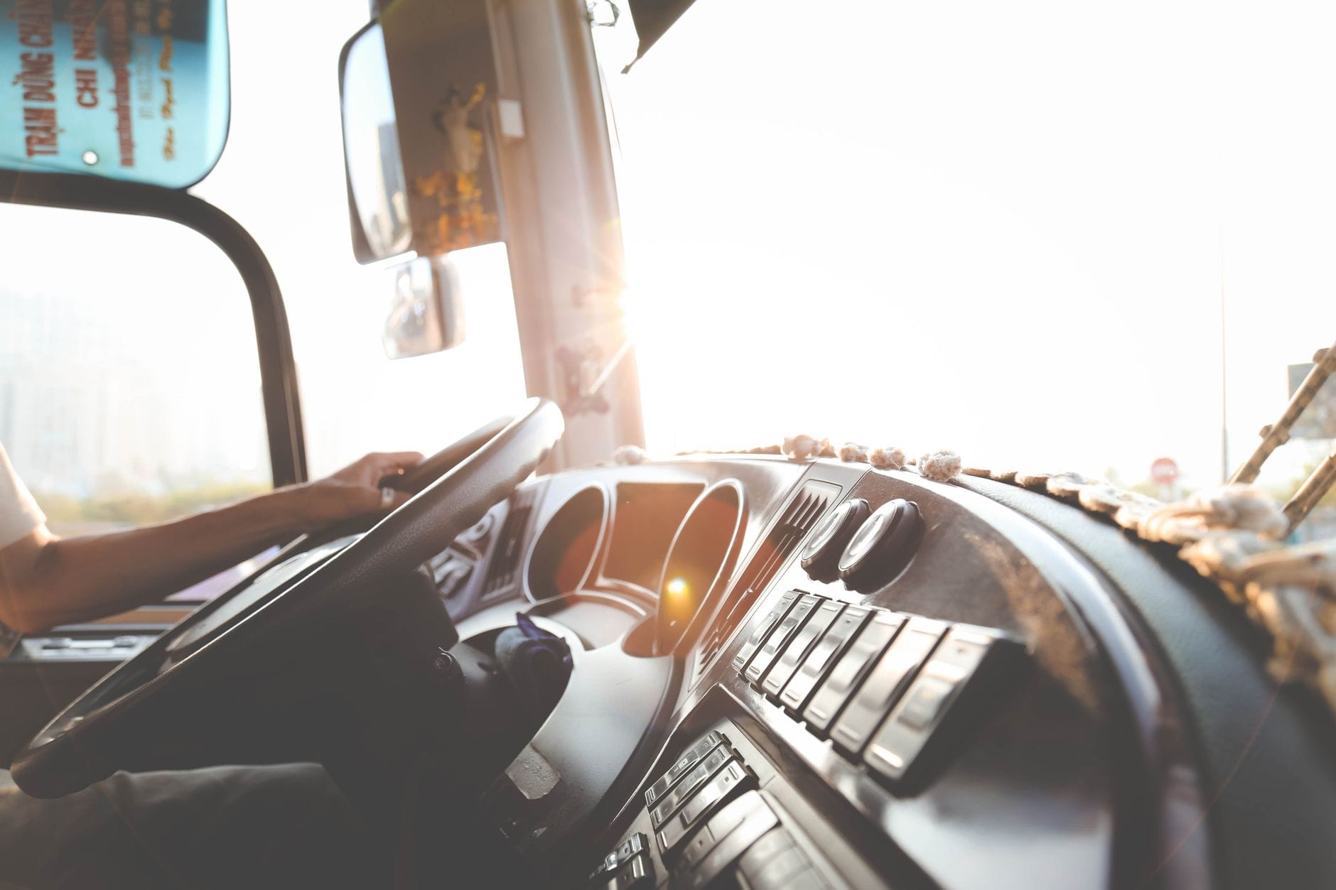 Kierowca autobusu prowadzący przez miejskie ulice w słoneczny dzień
