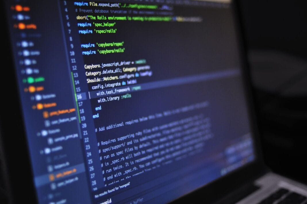 Zbliżenie ekranu komputera z kolorowym kodem programu na ciemnym tle